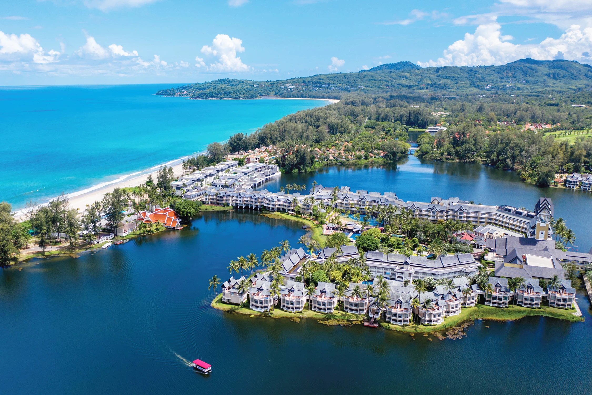 Панорамный вид сверху на курортный комплекс Лагуна с отелями у озера и морским побережьем